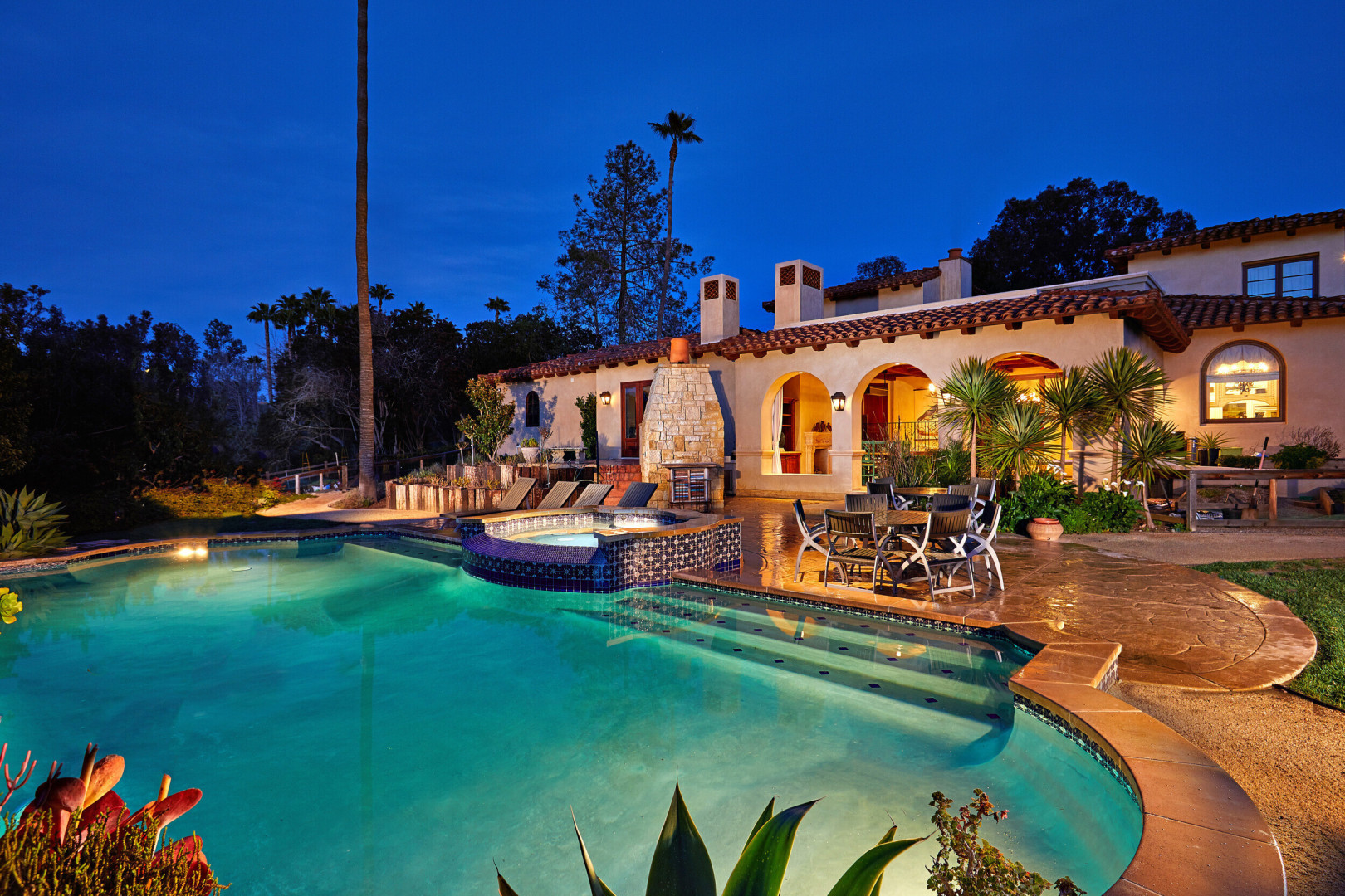 Rear elevation of tuscan inspired luxury home boasting a pool and hot tub, Rancho Santa Fe CA