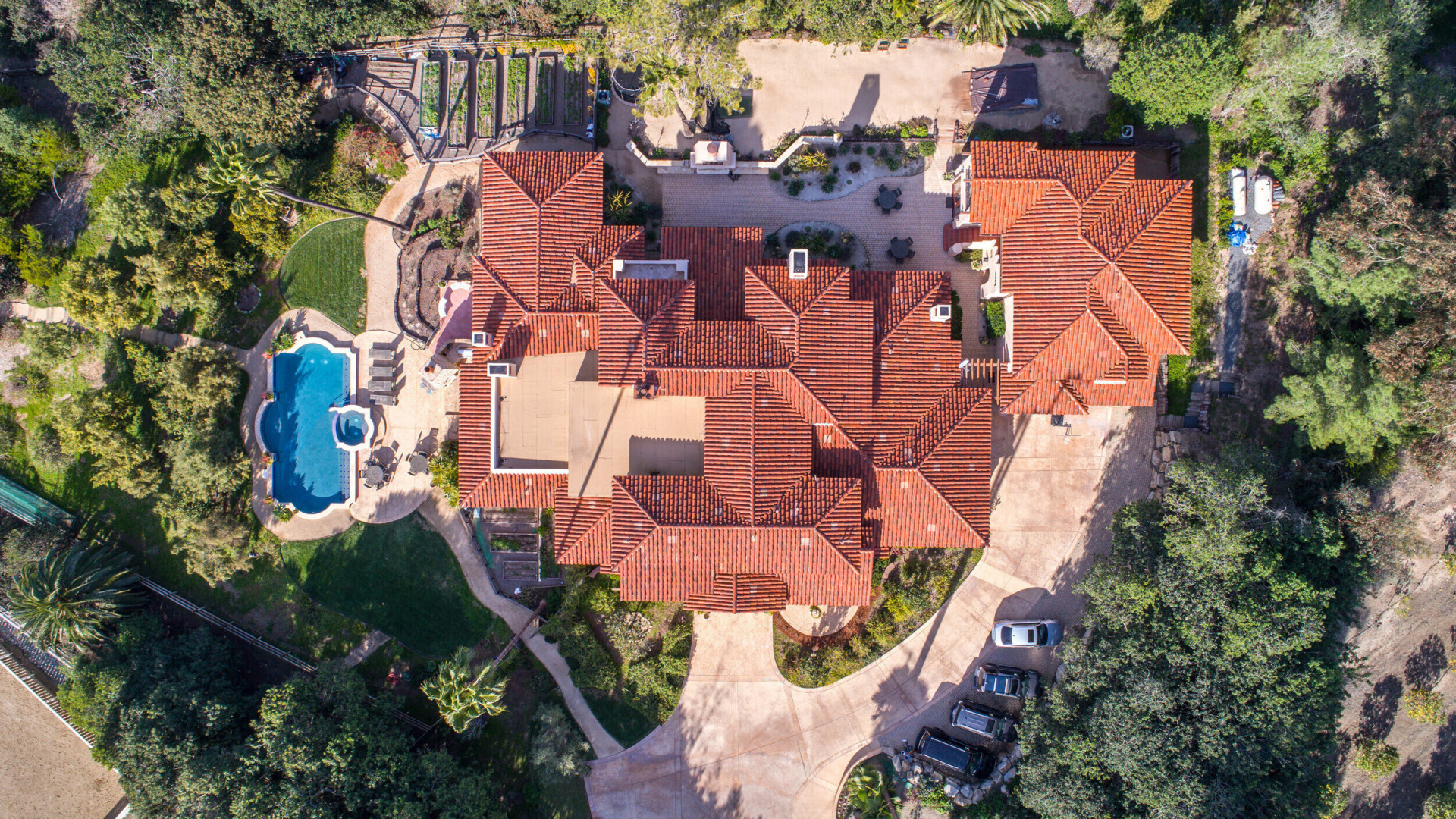 Aerial view of luxury custom home lined with plants and trees, Rancho Santa Fe CA